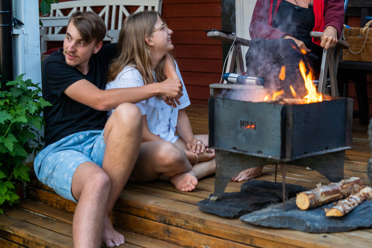 "Människor slappnar av kring en sprakande eld i en eldstad."
